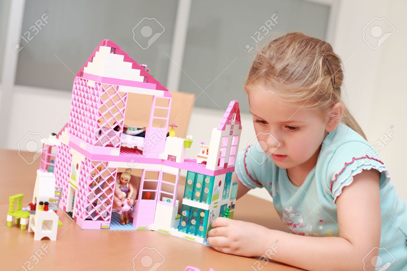 6850186-Cute-little-girl-plays-with-doll-s-house-Stock-Photo-playing.jpg